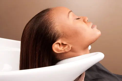 Woman with her hair in a sink at a salon