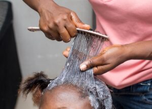 Hair Relaxer Lawsuit Stylist Applying Hair Relaxer on Client