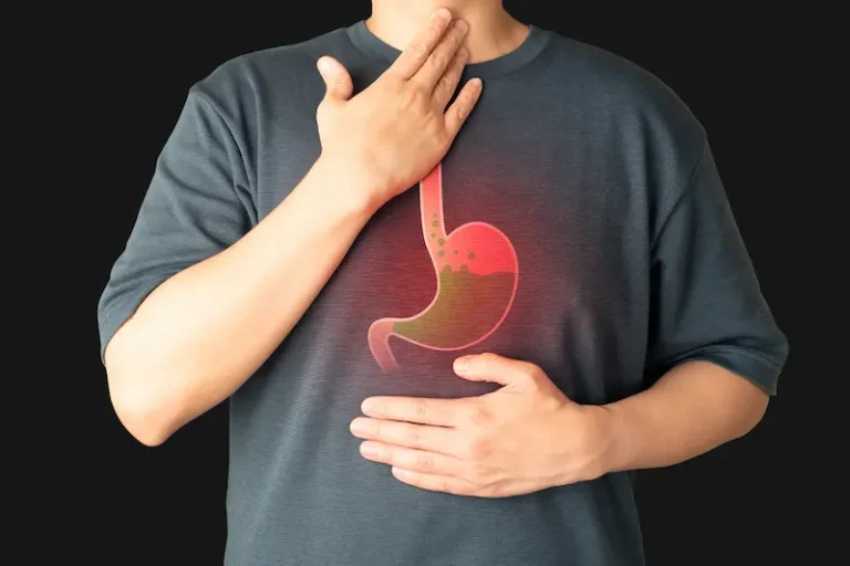 Zantac lawsuits concept: A person touches their throat and stomach while experiencing heartburn.
