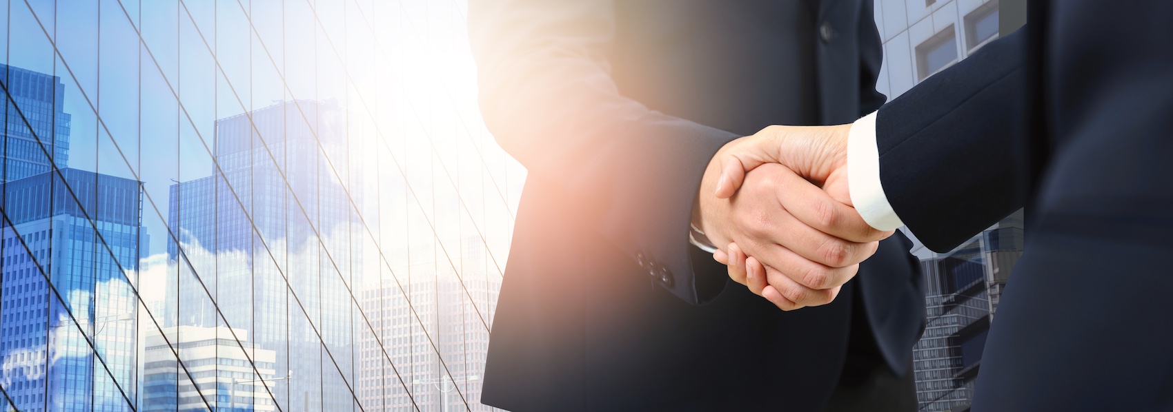 Choosing the Right Mass Tort Lawyer for Your Case Double exposure of a handshake between Caucasian male lawyers with a cityscape background.