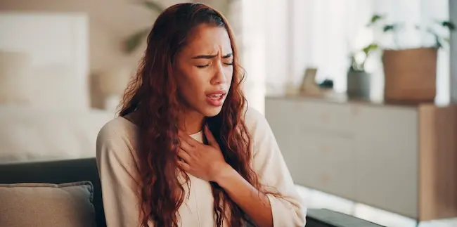 A woman is experiencing breathing difficulty and chest pain, illustrating pharmaceutical injury cases from dangerous or defective medications.