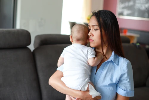 Worried mother with infant thinking about a San Diego birth injury lawyer
