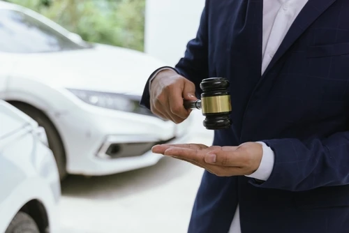 San Diego car accident attorney holding judge gavel beside automobile