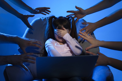 Roblox grooming represented by hands reaching at frightened little girl with laptop
