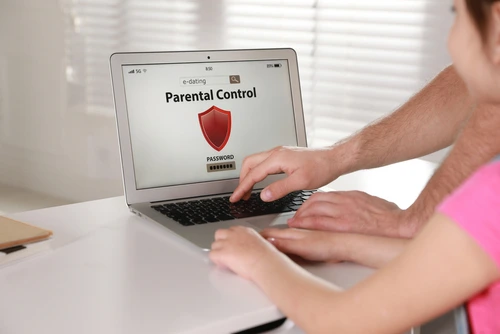 A father uses parental controls on his laptop to prevent Roblox grooming
